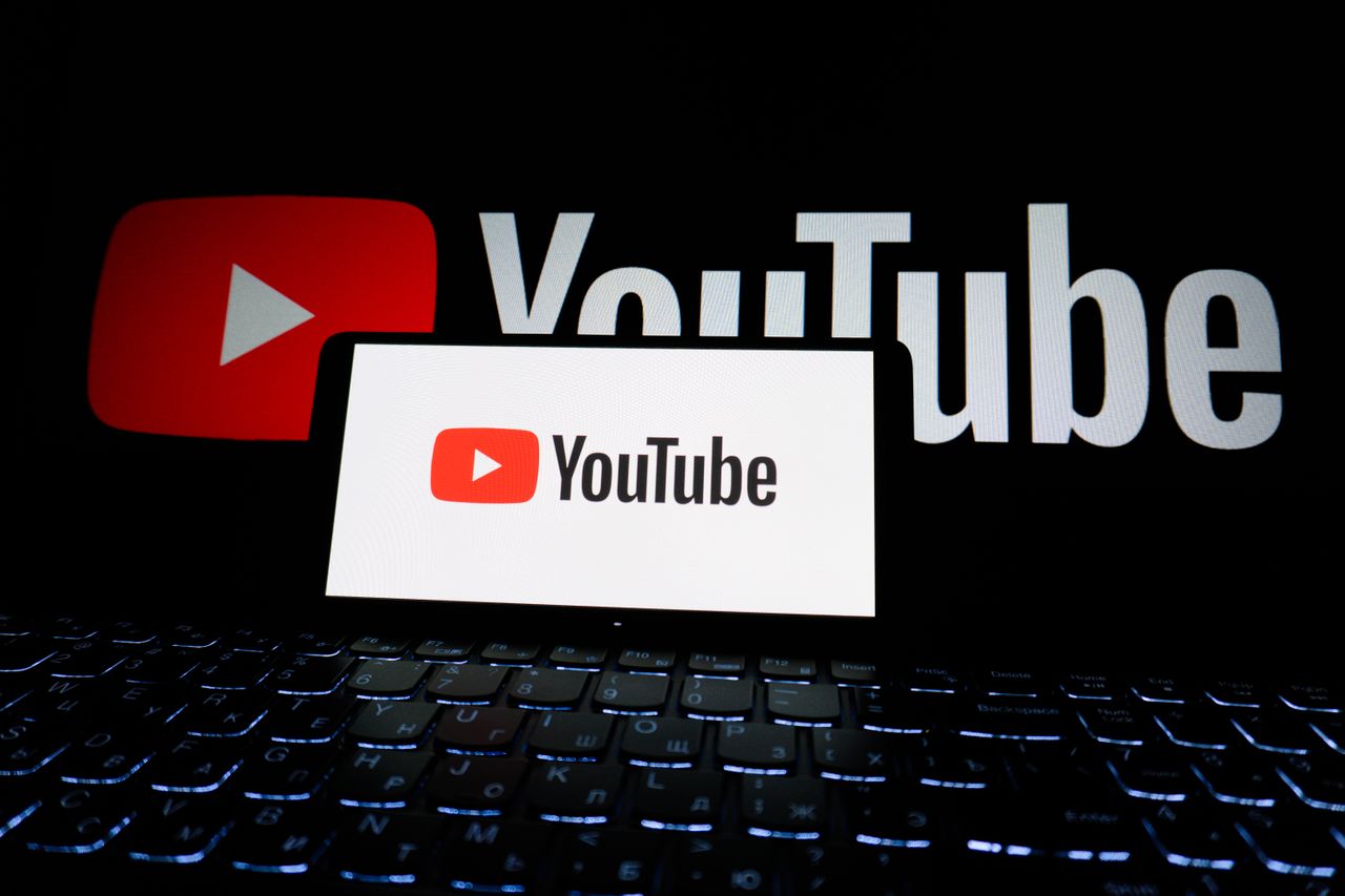 project-01-d Close-up view of the YouTube logo shown on a laptop screen in a dim setting.